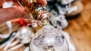 gold glitter being poured into clear ornament