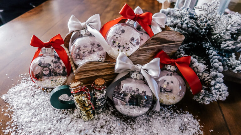 clear ornaments filled with photo and glitter sitting in wooden sleigh