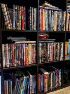 DVD cases stacked in black cubby shelves