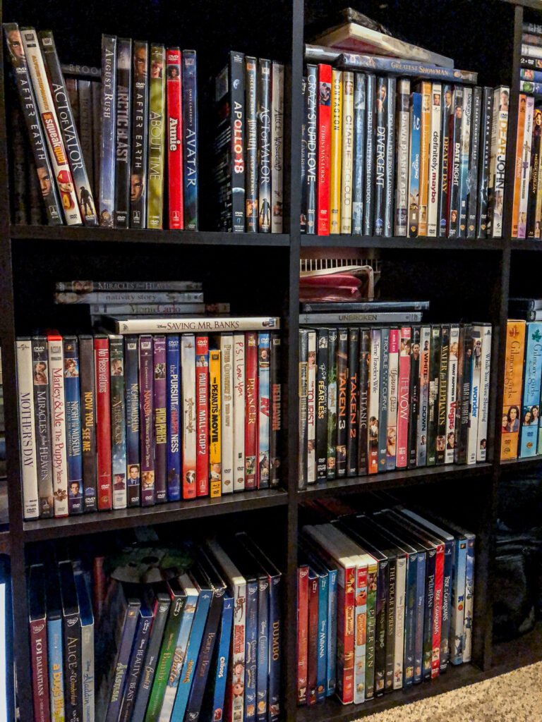 DVD cases stacked in black cubby shelves